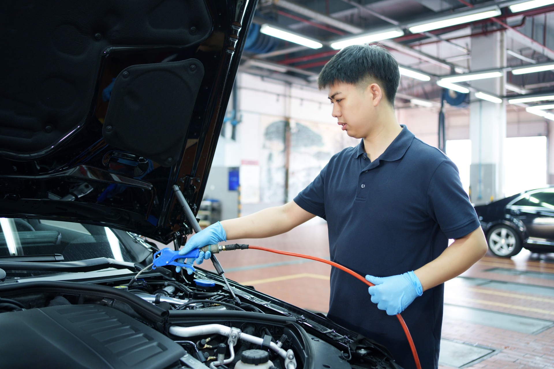 Worker cleaning engine compartment